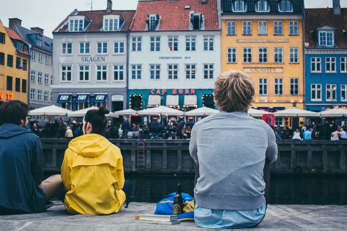 women between two men sitting beside river